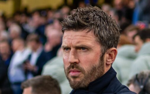 Michael Carrick standing on the touchline managing Manchester United during a Premier League match
