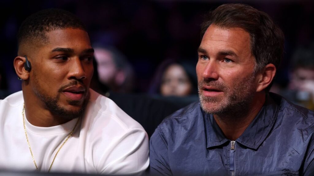 Anthony Joshua looking focused while standing ringside at a boxing match