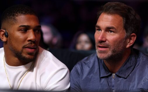 Anthony Joshua looking focused while standing ringside at a boxing match