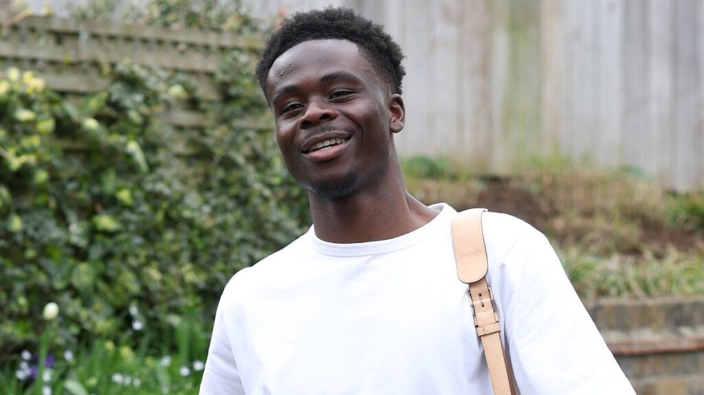 Arsenal winger Bukayo Saka clapping the fans on the pitch