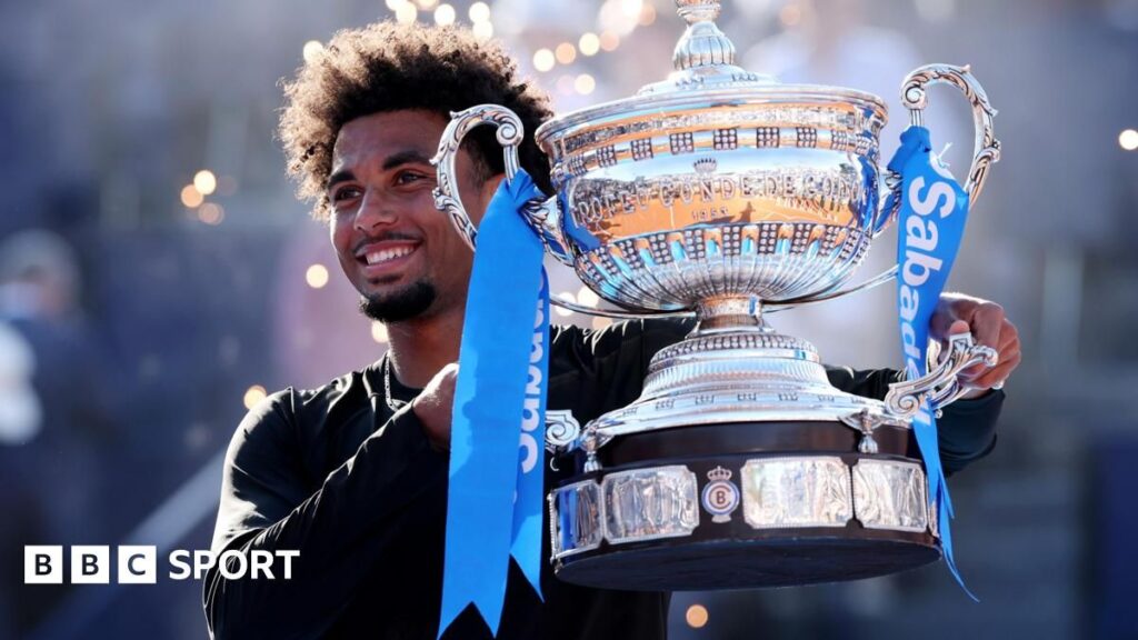 Arthur Fils celebrating with the winner's trophy on the clay court in Barcelona
