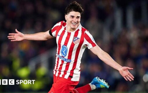 Julian Alvarez wearing an Atletico Madrid shirt and acknowledging the supporters