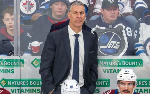 Colorado Avalanche head coach Jared Bednar standing behind the bench looking out onto the ice