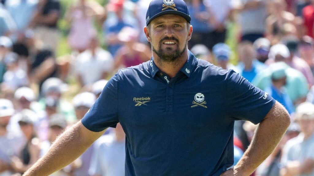 Bryson DeChambeau inspecting his golf club on the course at Augusta National