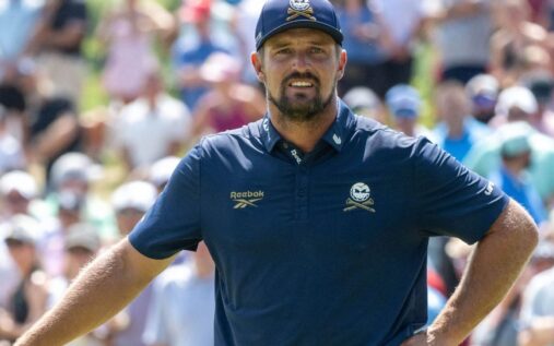 Bryson DeChambeau inspecting his golf club on the course at Augusta National