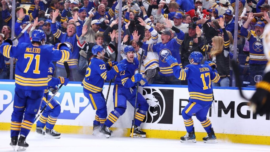 Buffalo Sabres players celebrating a goal against the Boston Bruins on the ice
