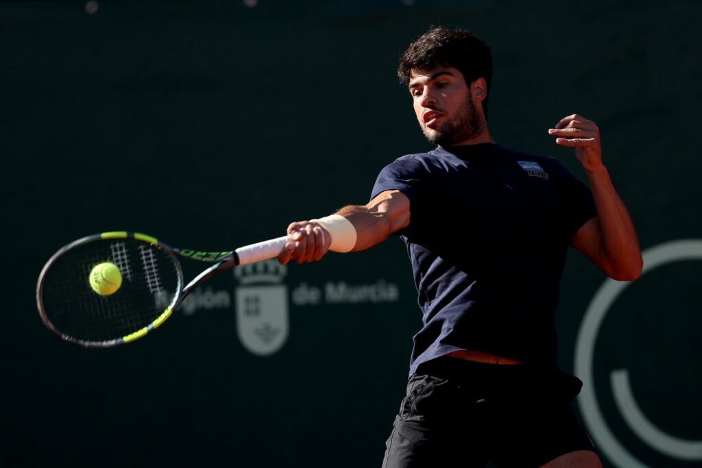 Carlos Alcaraz hitting a forehand on a clay court in Monaco