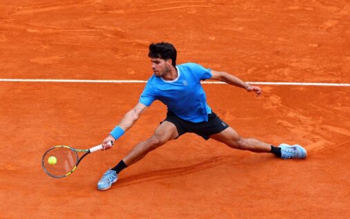 Carlos Alcaraz looking disappointed on a clay tennis court