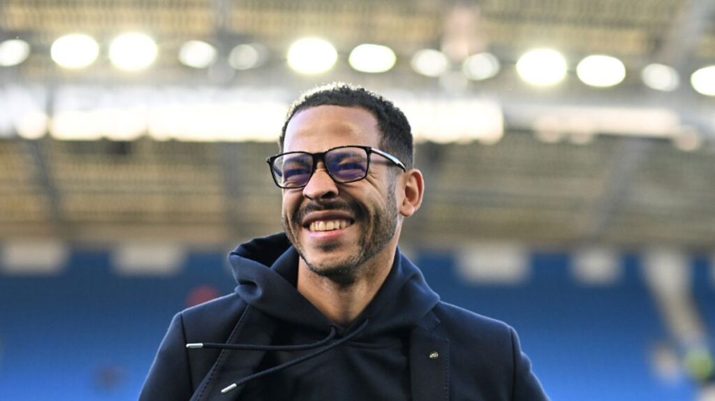 Liam Rosenior standing on the touchline managing Chelsea during a Premier League match