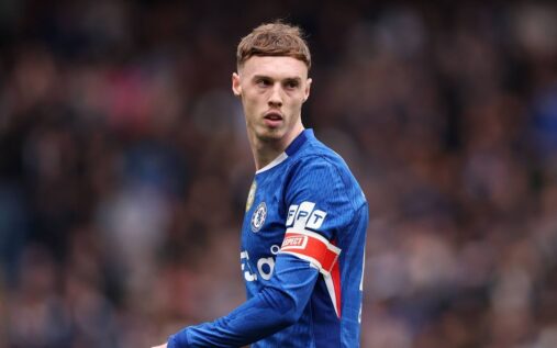 Cole Palmer looking dejected on the pitch wearing a blue Chelsea match shirt