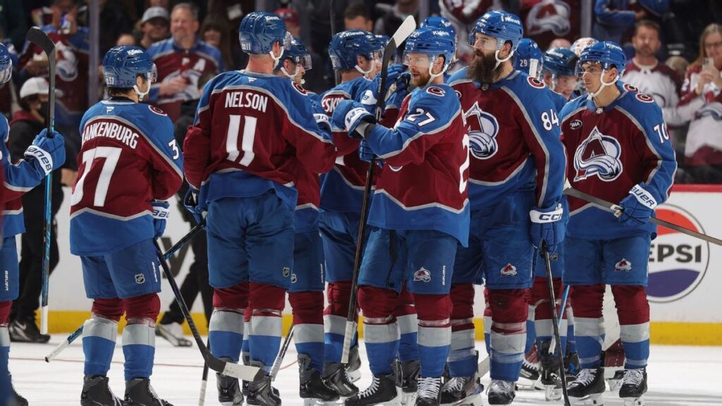 Nathan MacKinnon celebrating on the ice in a Colorado Avalanche jersey