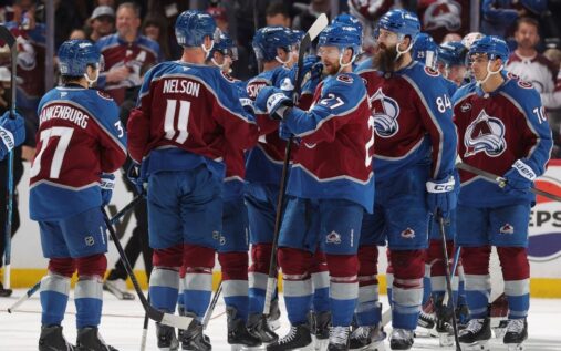 Nathan MacKinnon celebrating on the ice in a Colorado Avalanche jersey