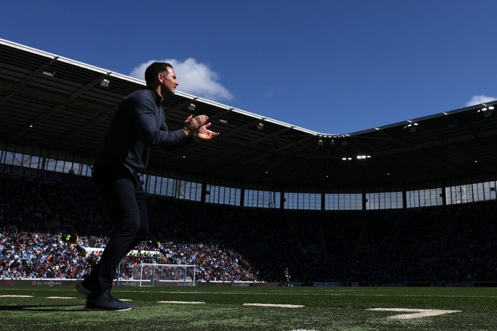Coventry City supporters waving sky blue flags in the stands at the CBS Arena
