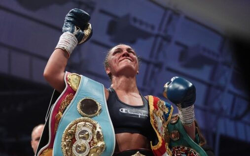 Ellie Scotney celebrating in the ring with her undisputed super-bantamweight championship belts