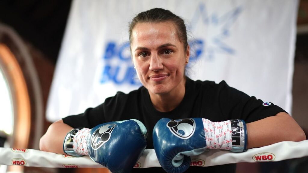 Ellie Scotney posing confidently with her super-bantamweight championship belts