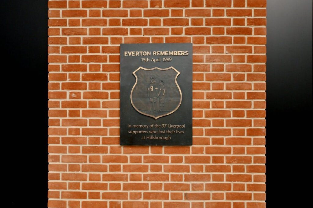 Statue of two young mascots holding hands in Everton and Liverpool shirts at Hill Dickinson Stadium