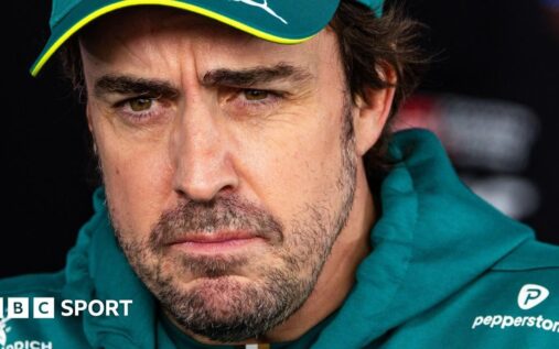 Fernando Alonso wearing his green Aston Martin racing overalls in the Formula 1 paddock