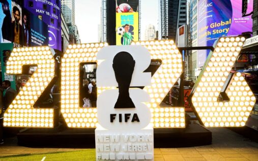 A packed football stadium displaying national flags during a major international tournament