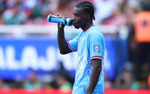 Football players taking a hydration break during a hot match at a stadium