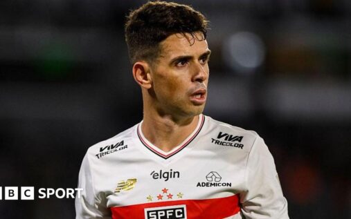 Brazilian midfielder Oscar waving to supporters while wearing a Sao Paulo football shirt