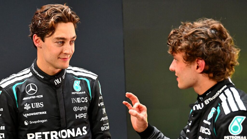 George Russell in Mercedes team gear speaking in the Formula 1 paddock