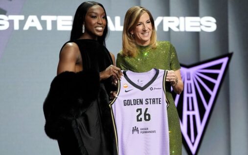 Flau'jae Johnson posing on stage at the WNBA draft in New York City