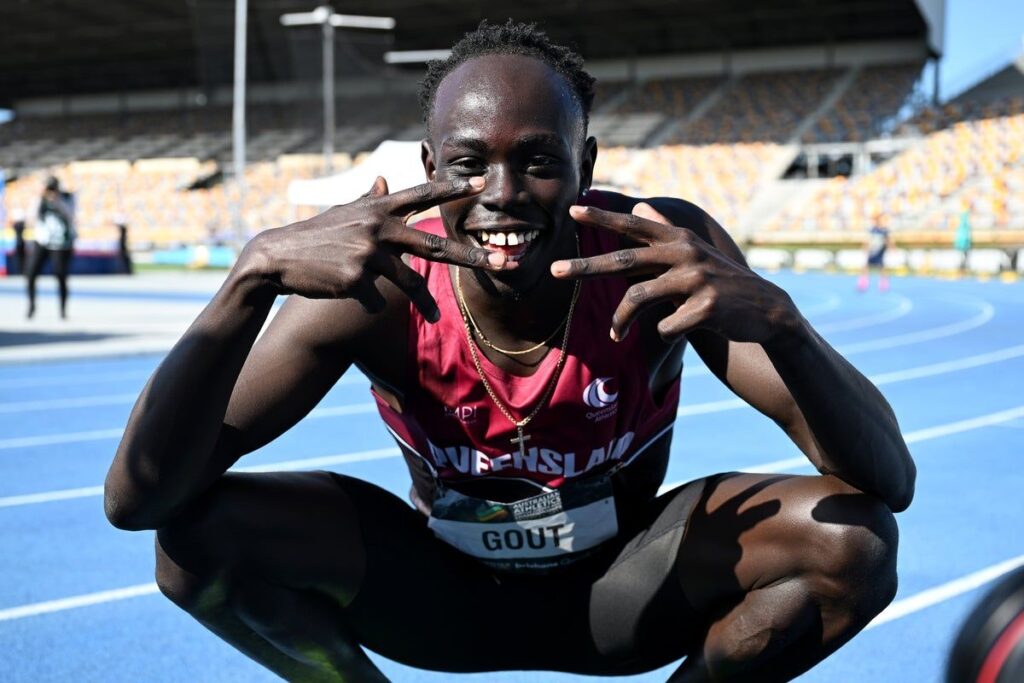 Sprinter Gout Gout waving to the crowd while competing on the athletics track