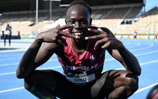 Sprinter Gout Gout waving to the crowd while competing on the athletics track