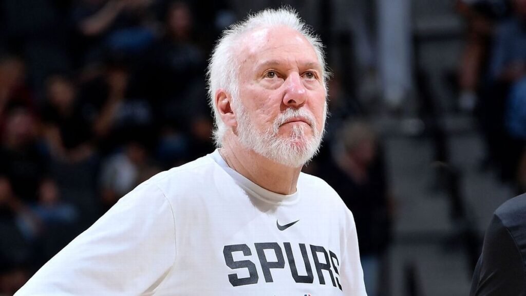 Former San Antonio Spurs head coach Gregg Popovich talking to players on a basketball court