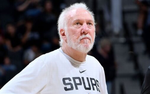 Former San Antonio Spurs head coach Gregg Popovich talking to players on a basketball court