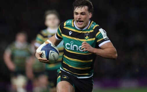 George Furbank running with the ball in a Northampton Saints rugby kit