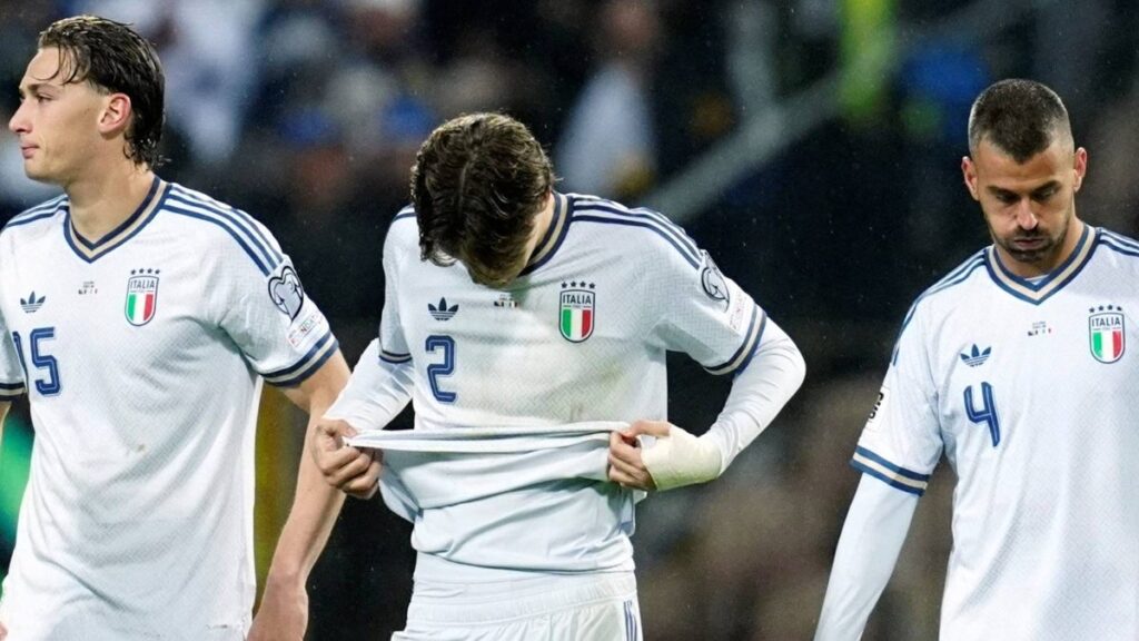 Dejected Italy national team players on the pitch following their play-off defeat