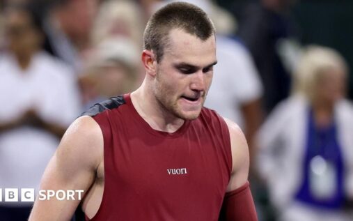 Jack Draper looking disappointed on a tennis court during a match