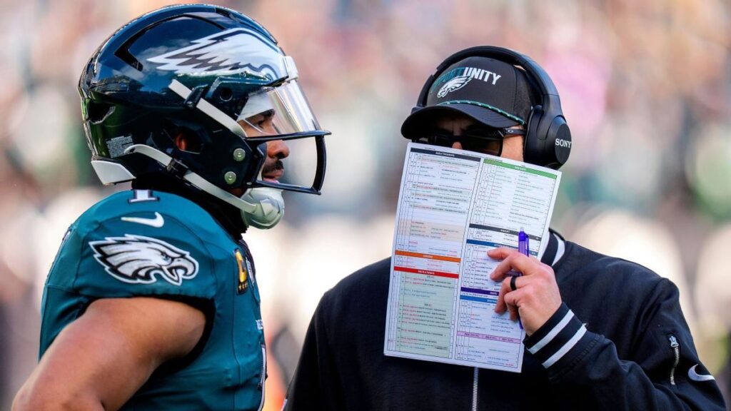 Jalen Hurts looking dejected on the field in his Philadelphia Eagles uniform during a playoff game