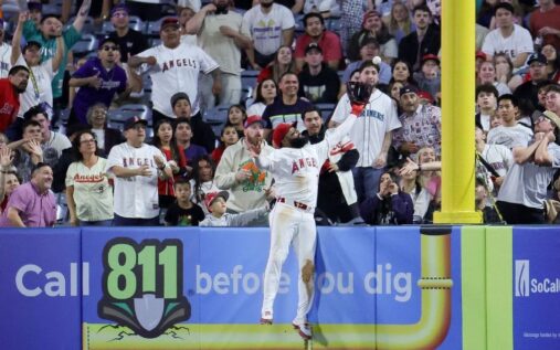 Los Angeles Angels outfielder Jo Adell leaping over the outfield wall to make a spectacular home run-robbing catch