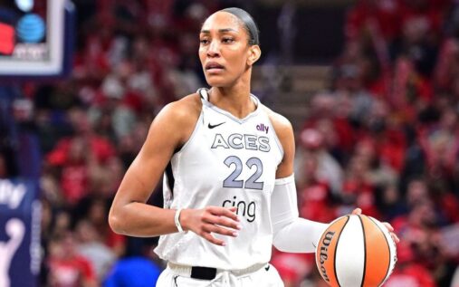 A'ja Wilson smiling in her Las Vegas Aces uniform on the basketball court