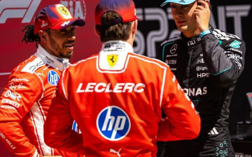 Lewis Hamilton walking through the Formula 1 paddock wearing Ferrari team clothing