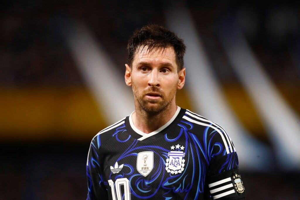 Lionel Messi wearing the Argentina national team kit looking serious on the pitch