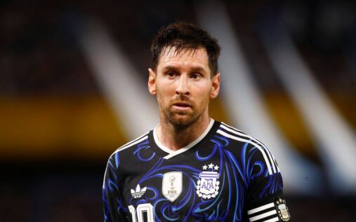 Lionel Messi wearing the Argentina national team kit looking serious on the pitch