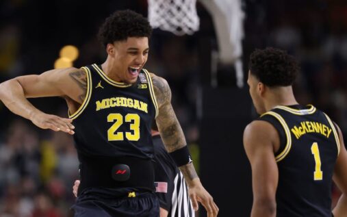 Michigan and UConn players competing on the basketball court during the NCAA championship
