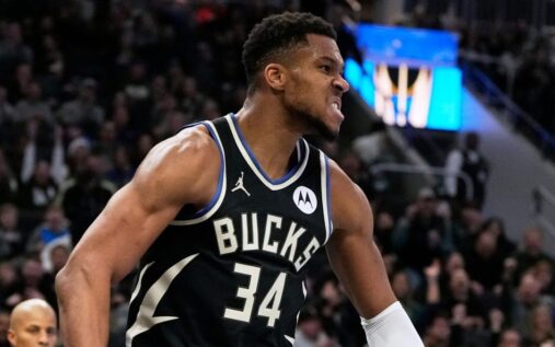 Giannis Antetokounmpo looking frustrated while sitting on the Milwaukee Bucks bench.