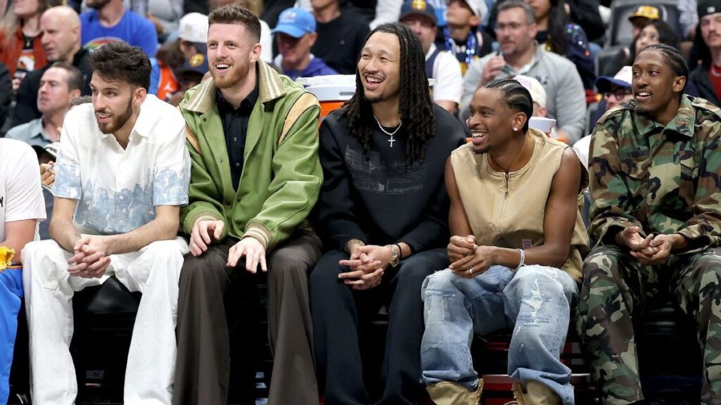 Shai Gilgeous-Alexander and Nikola Jokic sitting on the bench during an NBA game