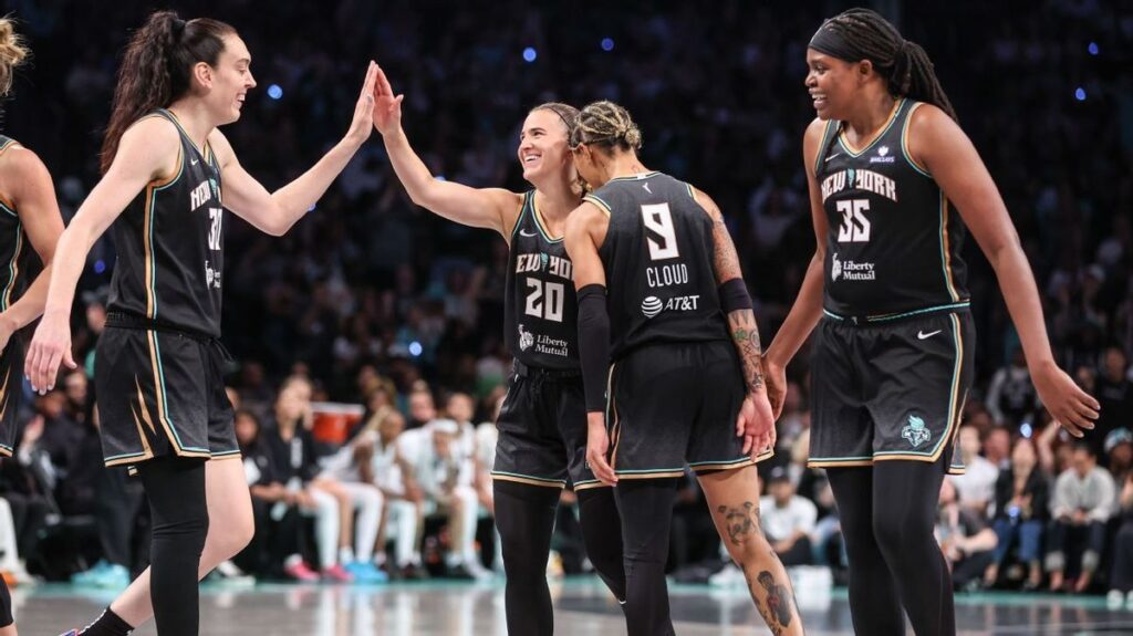 Breanna Stewart, Sabrina Ionescu, and Jonquel Jones celebrating together in New York Liberty uniforms