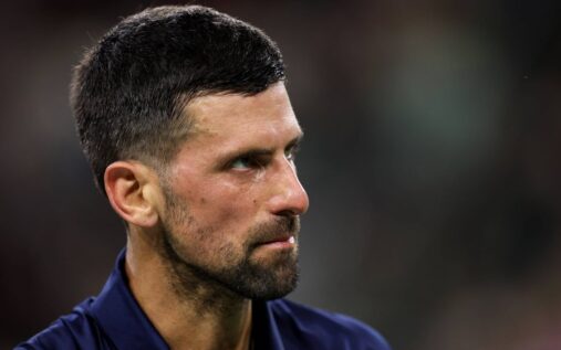 Novak Djokovic looking dejected on a clay tennis court