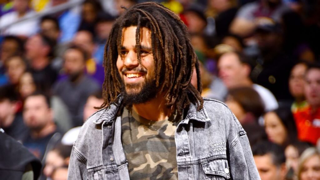 Grammy-winning rapper J. Cole standing on a basketball court