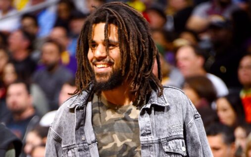 Grammy-winning rapper J. Cole standing on a basketball court