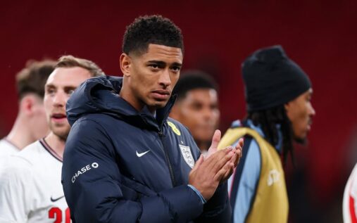 Jude Bellingham sitting on the England substitutes bench looking frustrated during an international friendly match