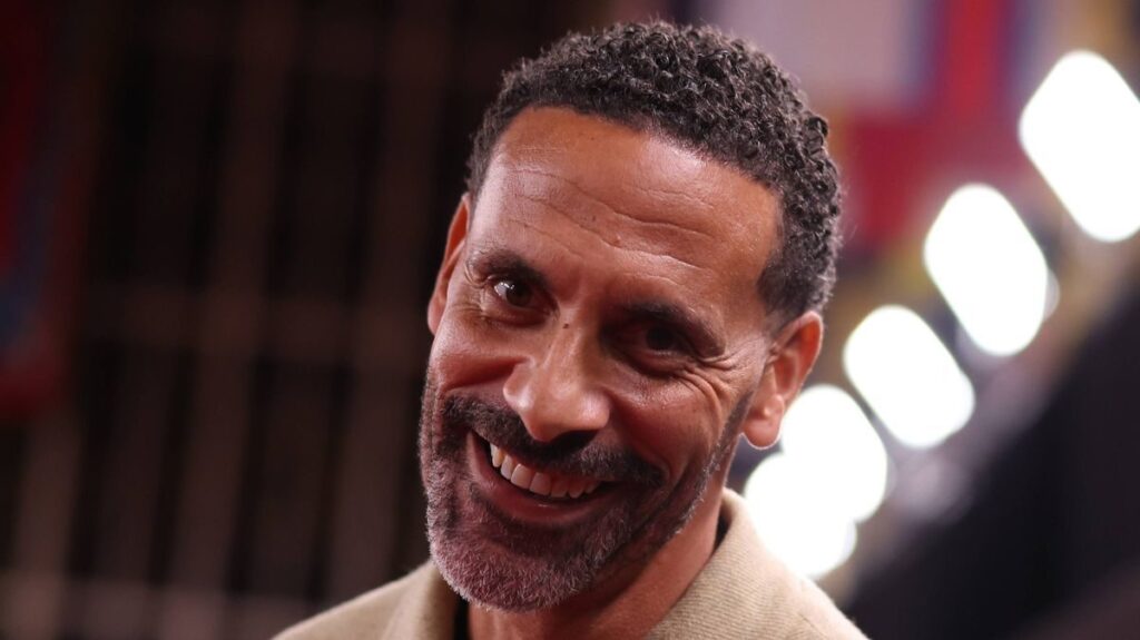Rio Ferdinand speaking into a microphone while working as a television pundit