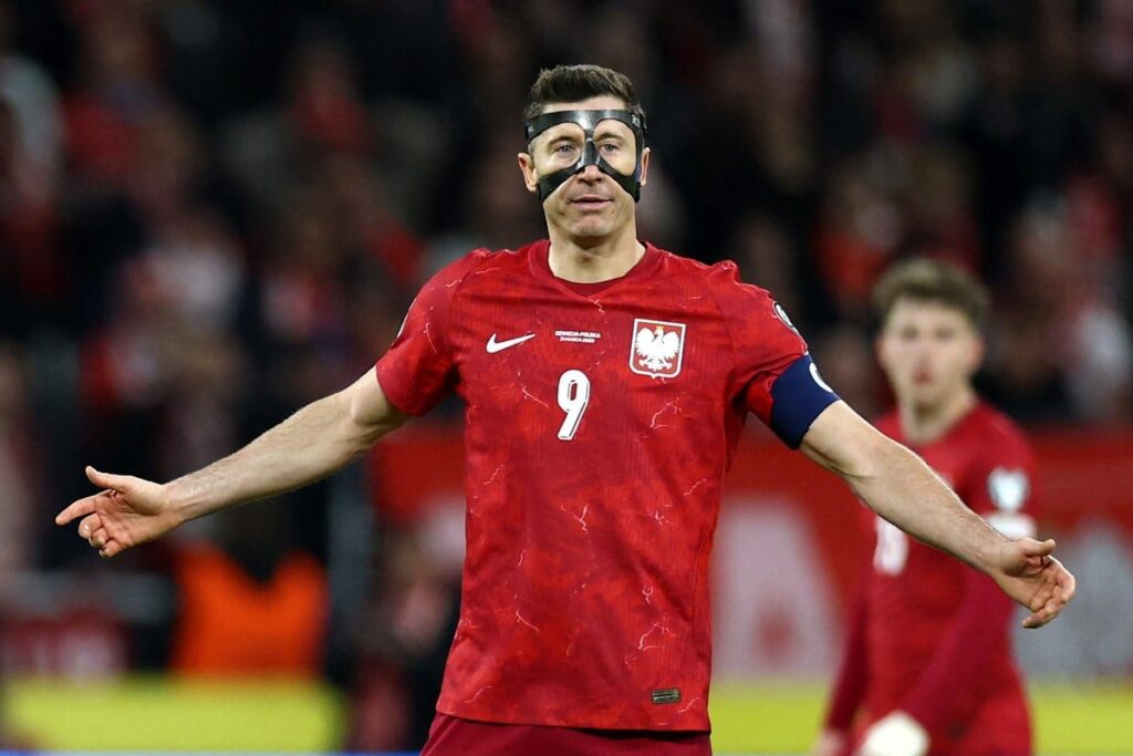 Robert Lewandowski holding his Poland captain's armband after a World Cup playoff defeat