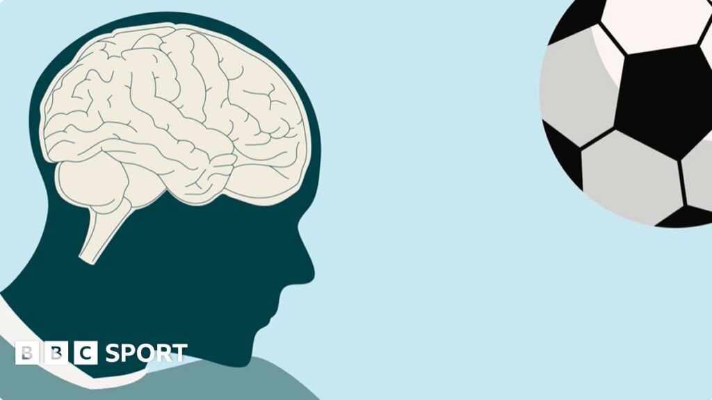 A modern football suspended in the air right before a player makes a header during a match